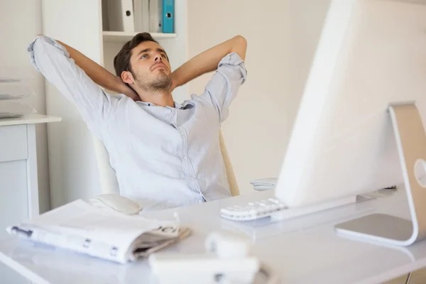 Hombre de negocios casual relajándose en el escritorio recostado hacia atrás — Foto de Stock