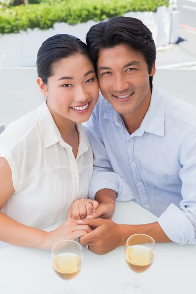 Lyckliga par hålla händer och med vitt vin — Stockfoto