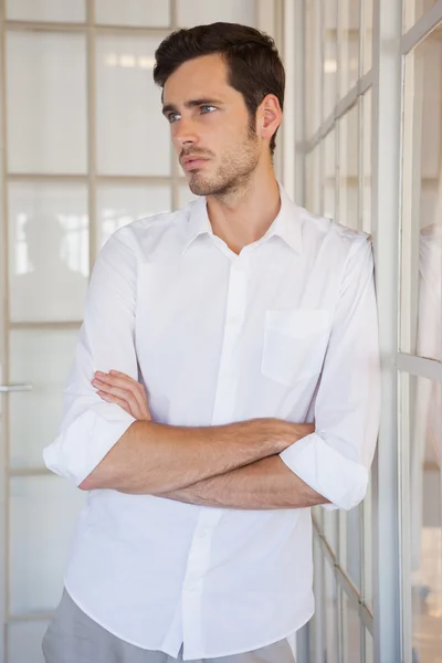 Casual upset businessman leaning against window — Stock Photo, Image