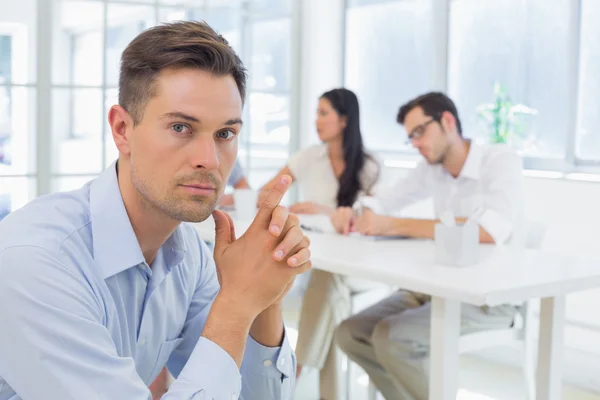 Empresario con equipo detrás de él — Foto de Stock