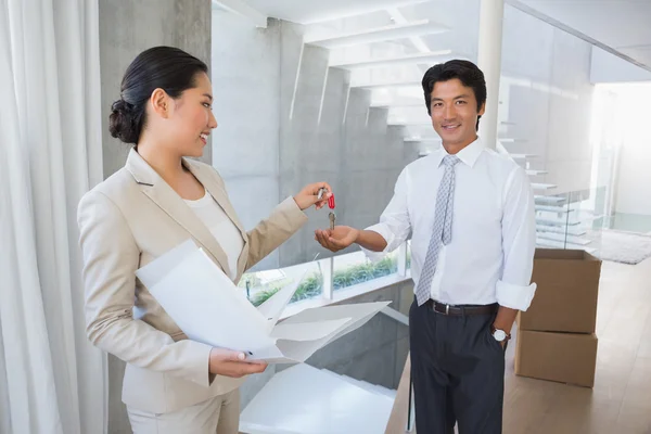 Estate agent giving house key to buyer — Stock Photo, Image