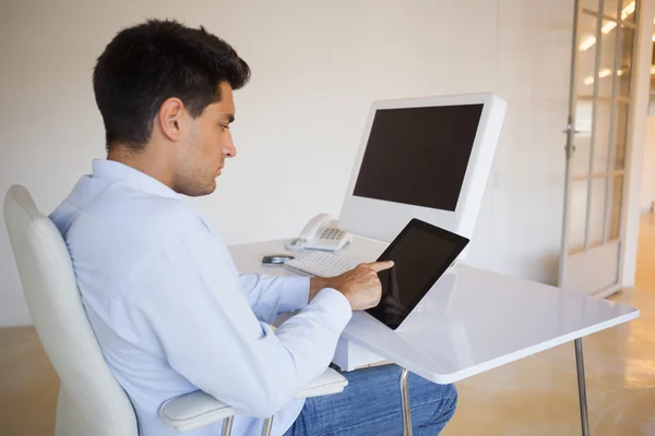 Businessman working on his tablet at his desk — Stock Photo, Image