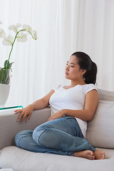 Mulher relaxante no sofá pensando — Fotografia de Stock