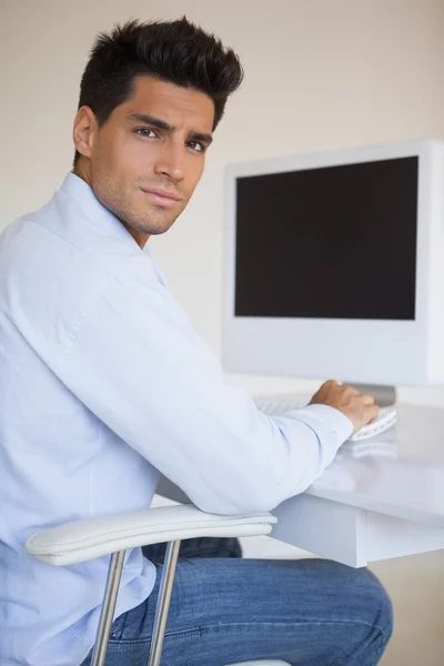 Hombre de negocios casual trabajando en su escritorio mirando a la cámara — Foto de Stock