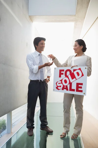 Agente inmobiliario dando llaves al nuevo dueño de la casa — Foto de Stock