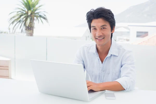 Lächelnder Mann mit seinem Laptop — Stockfoto