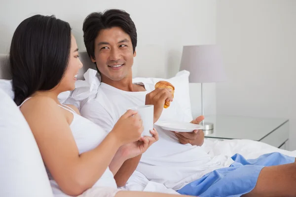 Happy couple having breakfast in bed — Stock Photo, Image