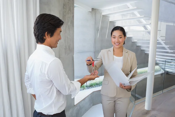 Estate agent giving house key to buyer — Stock Photo, Image