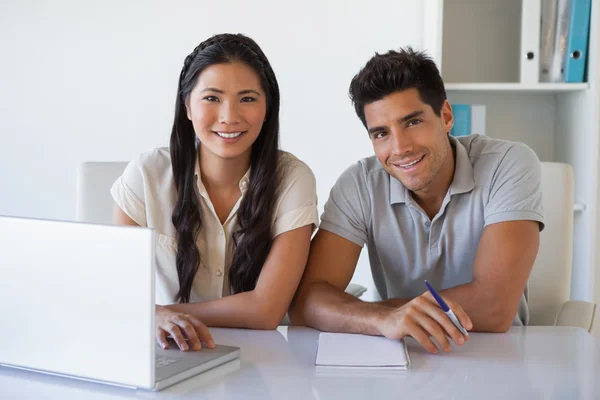 Casual business team using laptop together at desk — Stock Photo, Image