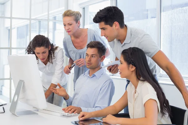 Бизнесмен показывает коллегам что-то на компьютере — стоковое фото