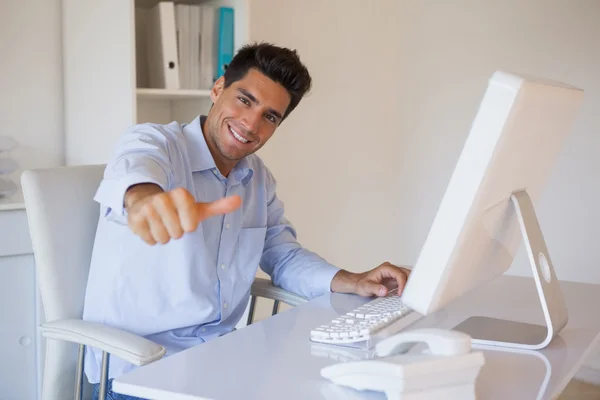 Casual affärsman ger tummen upp för kameran vid sitt skrivbord — Stockfoto