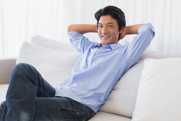 Homem feliz relaxando no sofá — Fotografia de Stock