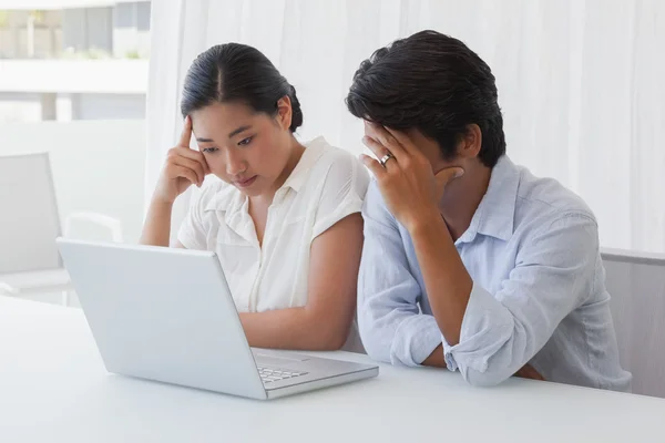 Allvarliga par använder laptop tillsammans — Stockfoto