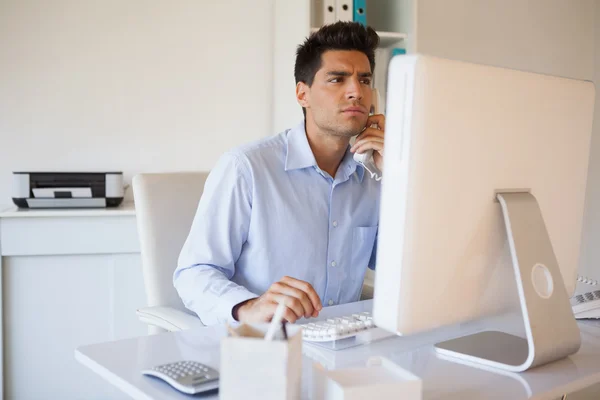 Uomo d'affari occasionale al telefono alla scrivania — Foto Stock