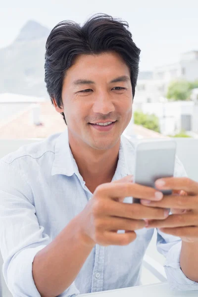 Glücklicher Mann beim SMS-Schreiben am Telefon — Stockfoto