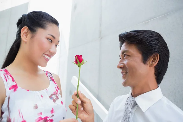 Man offering a red rose to girlfriend — Stock Photo, Image
