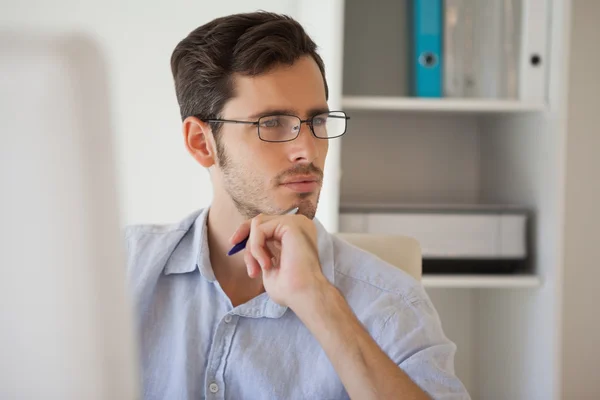 Casual businessman thinking at his desk — Stock Photo, Image