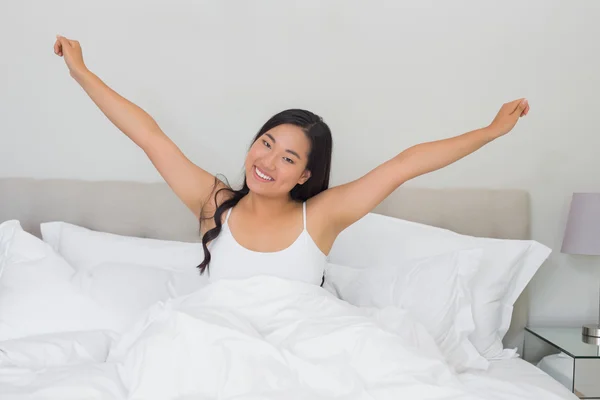 Gülümseyen kadın yatakta sabah germe — Stok fotoğraf