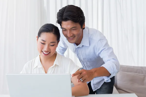 Casal feliz usando laptop juntos — Fotografia de Stock