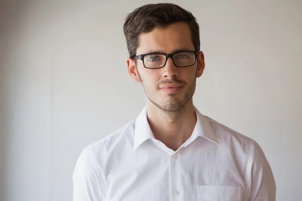 Homem de negócios casual sorrindo para a câmera usando óculos — Fotografia de Stock