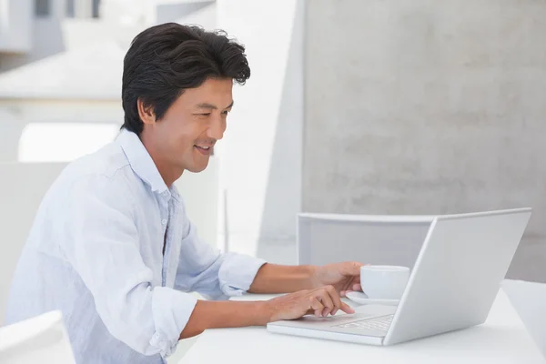 Lycklig man använder laptop med en kopp kaffe — Stockfoto