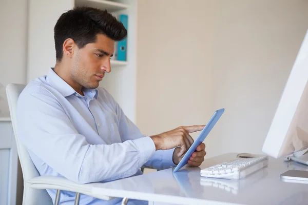 Onun masasında onun tablet üzerinde çalışan geçici iş adamı — Stok fotoğraf