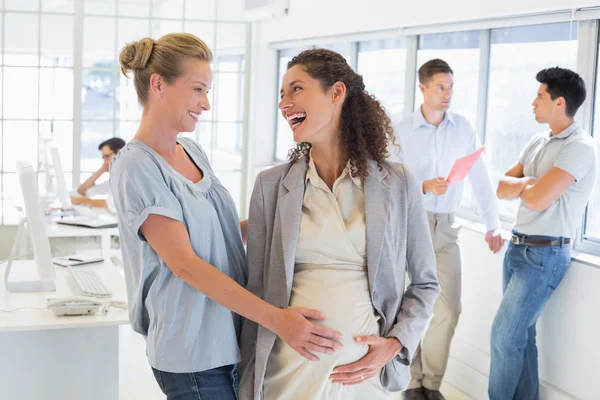 Zakenvrouw aanraken haar zwangere collega's buik — Stockfoto