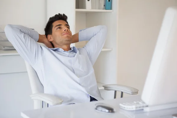 Casual businessman relaxing at desk leaning back — Stock Photo, Image