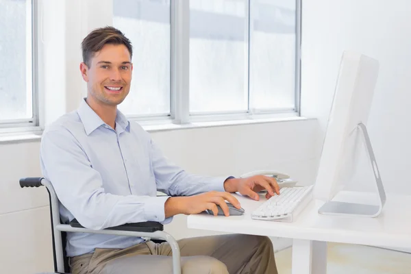 Casual zakenman in rolstoel werken aan zijn Bureau — Stockfoto