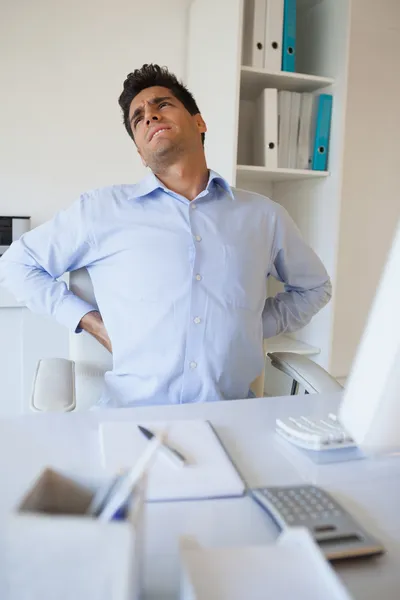 Casual empresário esticando a dor nas costas — Fotografia de Stock