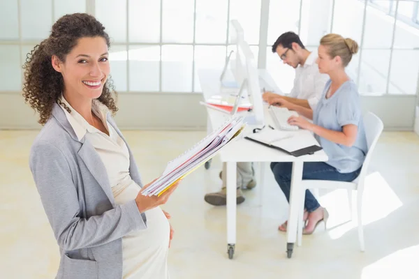 Pregnant businesswoman with team behind her — Stock Photo, Image