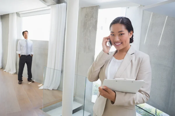 Agent immobilier parlant au téléphone avec l'acheteur en arrière-plan — Photo