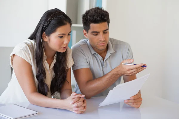 Casual business team reading document together at desk — Stock Photo, Image