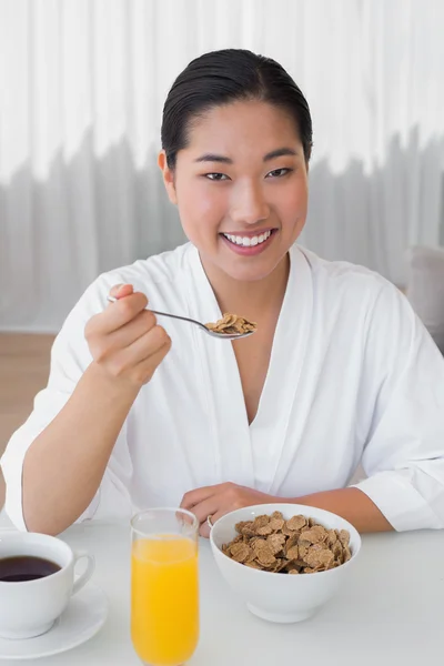 Happy woman in bathrobe having her breakfast — Stock Photo, Image