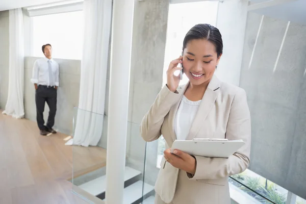 Agente immobiliare che parla al telefono con l'acquirente in background — Foto Stock