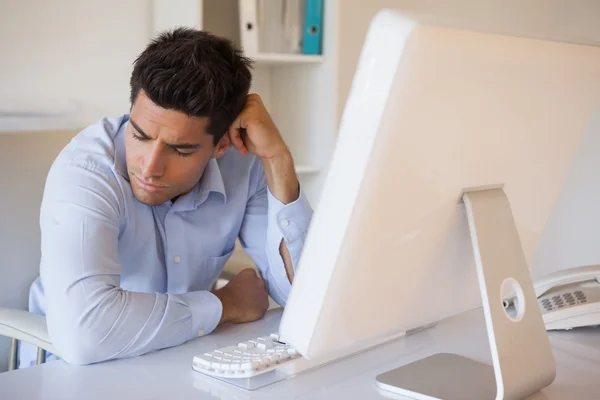 Casual businessman slumped at his desk — Stock Photo, Image