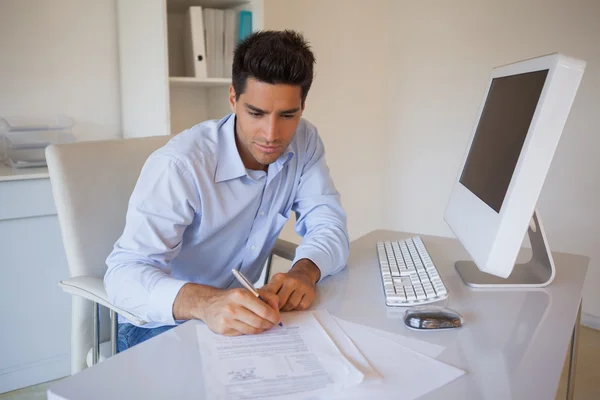 Uomo d'affari casual seduto alla scrivania a scrivere — Foto Stock