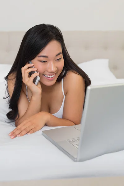 Glückliche Frau schaut auf Laptop am Telefon — Stockfoto