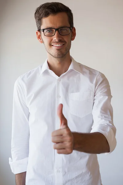 Casual businessman giving thumbs up to camera — Stock Photo, Image