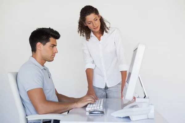Casual business team looking at computer together at desk — Stock Photo, Image