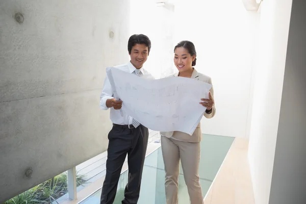 Estate agent looking at blueprint with potential buyer — Stock Photo, Image