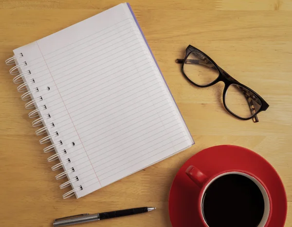 Overhead of notebook and glasses with pen and coffee cup — Stock Photo, Image