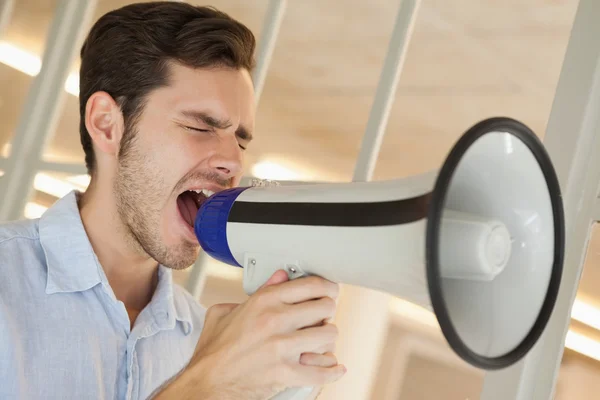 Příležitostné podnikatel křičí přes megafon — Stock fotografie
