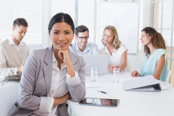 Casual mujer de negocios sonriendo a la cámara durante la reunión — Foto de Stock