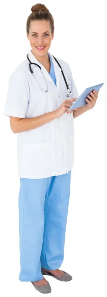 Nurse in tunic using tablet pc — Stock Photo, Image