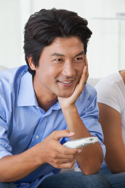 Happy man sitting on couch watching tv — Stock Photo, Image