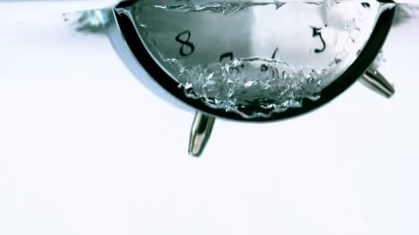 Alarm clock falling into water — Stock Video