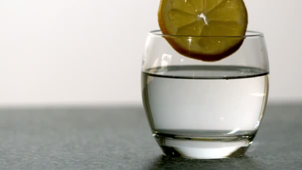 Шматочок апельсина падає в склянку — стокове відео