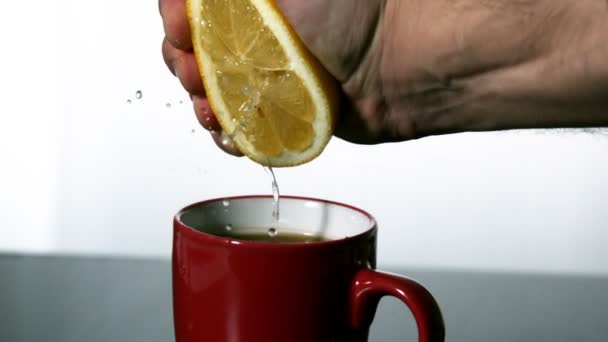 Man squeezing lemon into mug — Stock Video