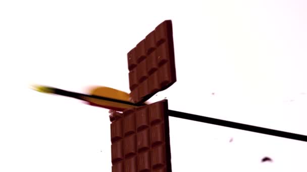 Arrow shooting through a chocolate bar — Stock Video